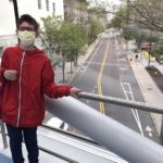Jared, who has scoliosis, in a red jacket on the Boston Children's skybridge overlooking an empty street.