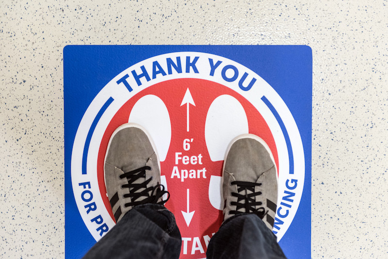 Sticker on the floor reminding people to maintain at least 6 feet of physical distance to prevent the spread of coronavirus.
