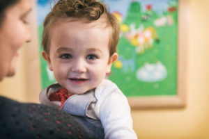 bryson, who has an anorectal malformation, smiles over his mother's shoulder