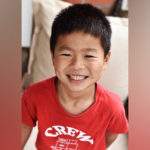 steven, who was born with. an anorectal malformation, smiles and wears a red t-shirt