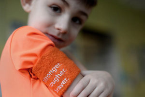 James, who had a stroke, shows an arm and that reads "stronger, tougher"