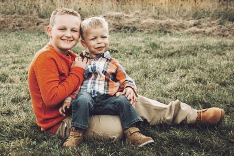 Rylan, who had a laryngeal cleft, sits on his older brother's lap