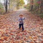 Finn, who was born with clubfoot, runs down a leafy path.