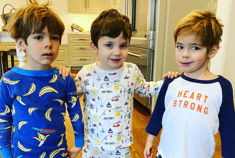 Evan and West, both who have congenital heart disease, pose with Evan's brother in a kitchen