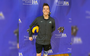 Jim, who has PK deficiency, stands holding a volleyball