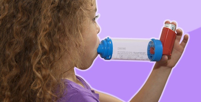 girl with asthma inhaler with spacer