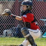 an action shot of brendan, who had bladder diverticula, acting as his baseball team's catcher