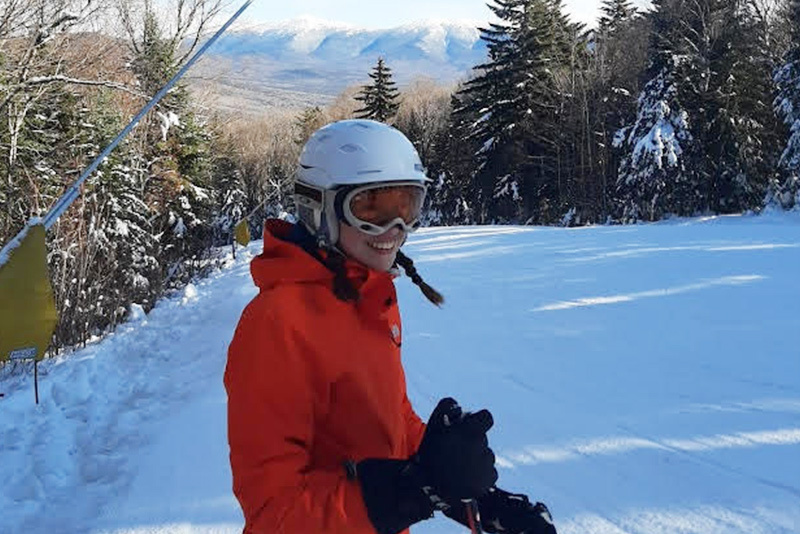 Lucie, who has chronic pain, on a ski trail. She is wearing a red jacket and a helmet.