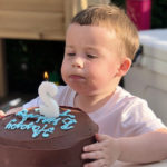 tyler blows out a candle on his birthday cake after treatment for a laryngeal cleft