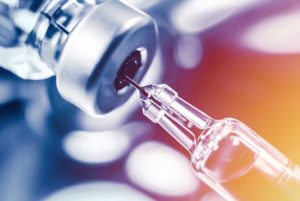 Close-up photo of a needle taking a vaccine from a vial