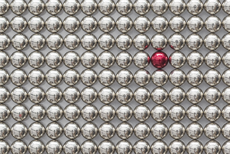 photo of tiny silver magnets and one red magnet