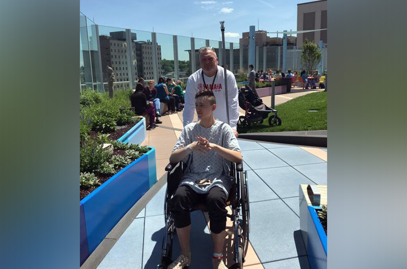 Jack Jr. is pushed by his father on the roof deck of the hospital after his heart valve surgery.