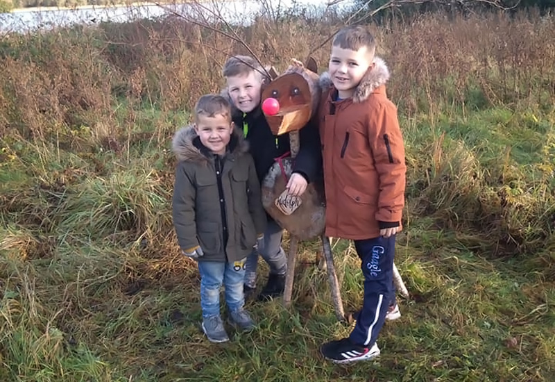 Matthew, who was born with ALD, poses with his two brothers in a field