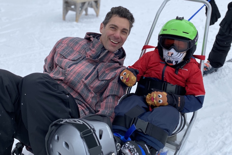 Colin, who was born with infantile scoliosis, hangs out with Dr. Graham at the top of a ski slope. 
