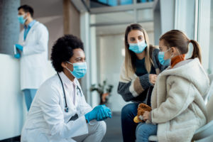 Mother and daughter talk to doctor in hallway of hospital