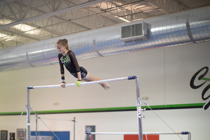 Ashley, who was born with symbrachydachtyly, prepares for a flip on the parallel bar. 