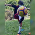 cooper, who has. cerebral palsy, kicks a soccer ball.