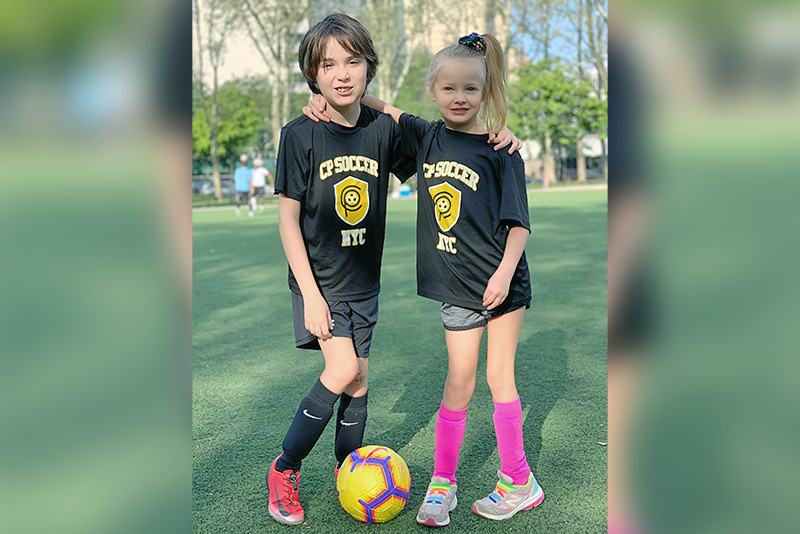 Cooper poses on the soccer field with one of his sisters.