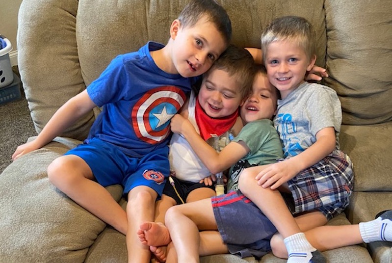 Joshy, who had a kidney transplant, plays on the couch with his three older brothers. 