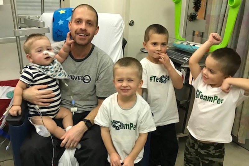 Joshy, who had a kidney transplant, in the hospital with his father and three brothers. 