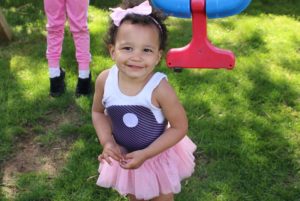 Jeanne plays outside wearing a tutu and the brace that is correcting her infantile scoliosis.