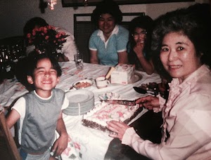 Michael as a young boy with his grandmother as she prepares to cut his birthday cake. 