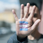 a photo of a hand with the transgender flag painted on it