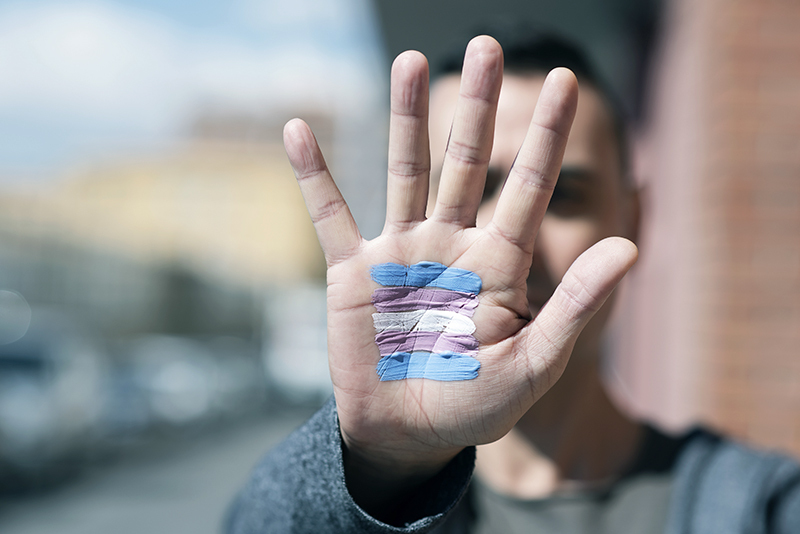 a photo of a hand with the transgender flag painted on it