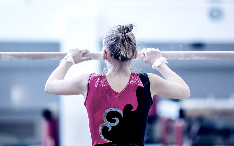 A gymnast prepares for a routine on the parallel bars. Research has found that urinary incontinence is a common experience for female athletes.