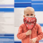 john, who had hepatoblastoma, holds a heart-shaped balloon