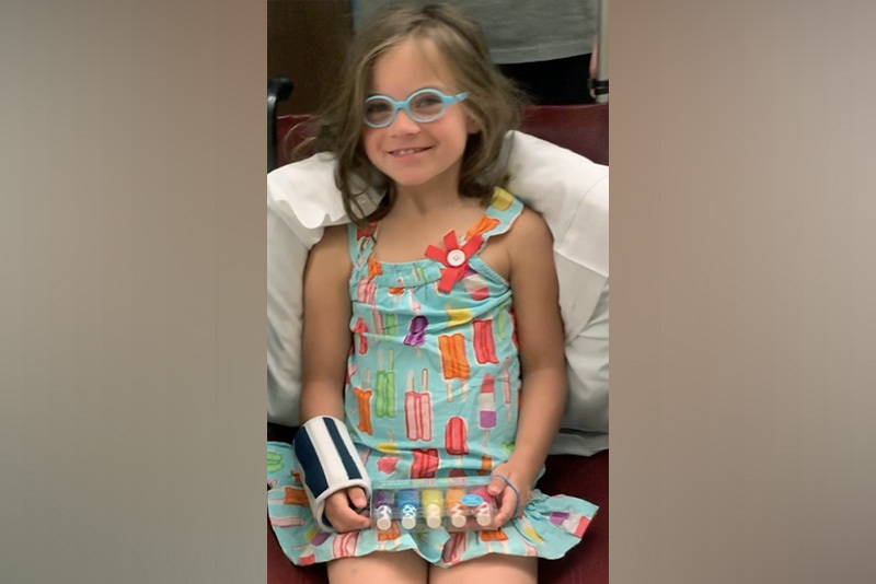 Scarlet, who had SDR surgery, shows a bottle of nail polish