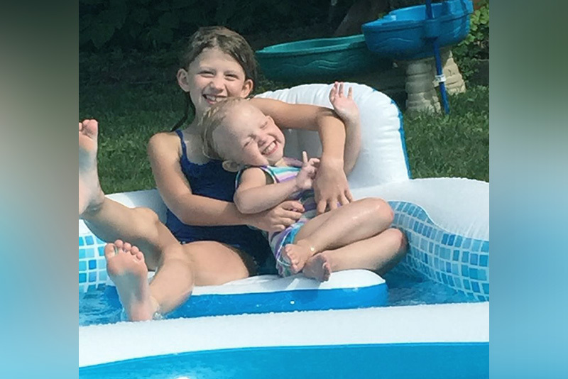 Sarah, who has biliary atresia, and her big sister, Norah, float in a pool