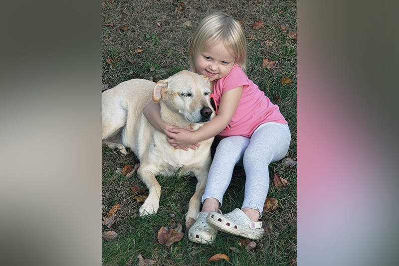 Sarah, who has biliary atresia, plays with her dog, Grace.