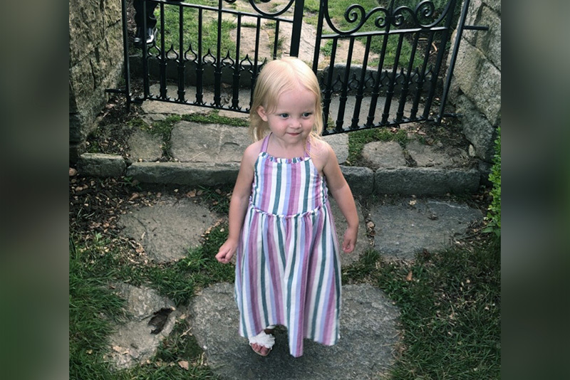 Sarah, who has biliary atresia, wears a striped dress