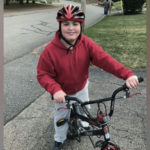 a photo of austin riding his bike after surgery for pediatric stroke