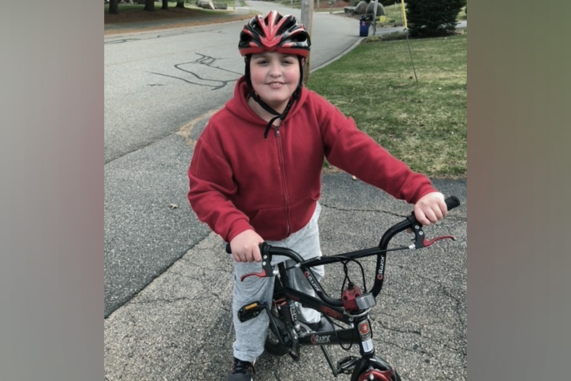 a photo of austin riding his bike after surgery for pediatric stroke
