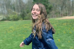 a photo of abby in a field. she is happy and smiling
