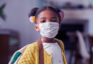 a little girl wearing a mask to help protect against delta variant