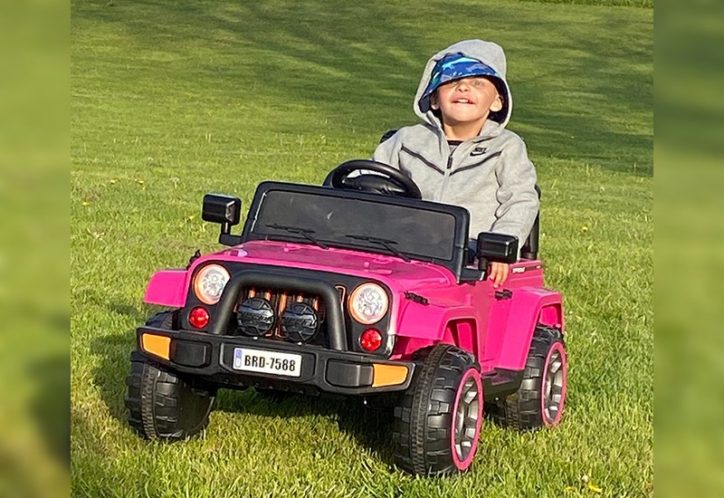 a boy riding in a miniature jeep