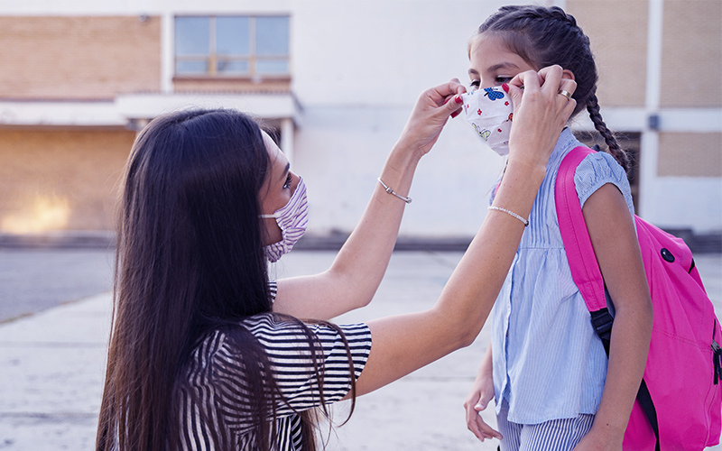 Woman fixing mask on child