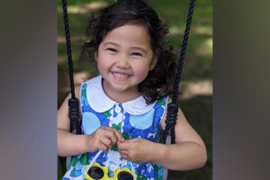 chalotte sits on a swing and smiles