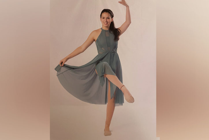 drew dances in a ballet dress. her toe is pointed and one of her arms is lifted over her head