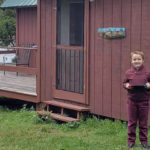 jacob stands in front of a cabin