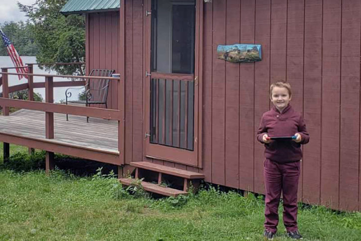 jacob stands in front of a cabin
