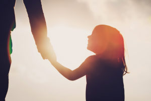 A young girl looks up at her parent.