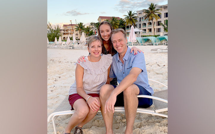 Emma on a beach with her parents, Melissa and Jeremy