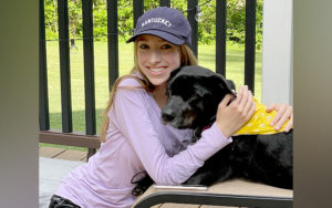 emma hugs her dog after treatment for achalasia