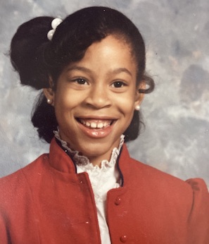 Tyonne Hinson as a young girl smiles for a school portrait.