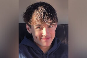 aiden, who has chronic pain, smiles at the camera