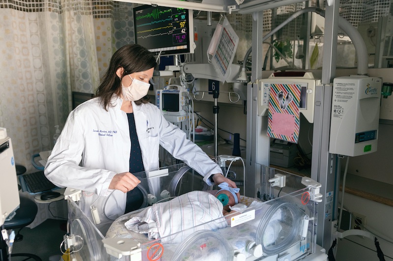 Alt text: Newborn Medicine physician Sarah Morton, MD, PhD, attending a baby girl in the NICU.